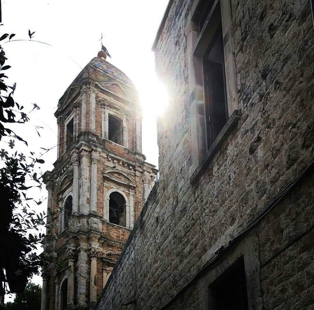 A historic building with a bell tower and arched windows.