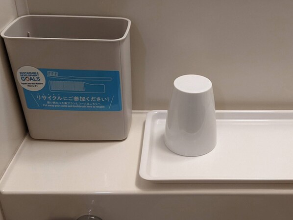 A trash bin with a recycling label and a white cup on a tray. - Toyoko Inn Tsushima Hitakatsu (Tsushima)