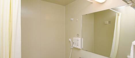 A bathroom with a shower, a sink, a mirror, and a towel rack.
