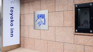 Een bord voor Toyoko Inn met een groot, duidelijk logo en Japanse tekens.