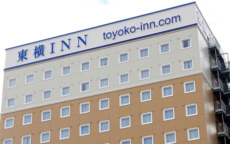 A multi-story building with a sign reading "TOYOKO INN" and the website "toyoko-inn.com".