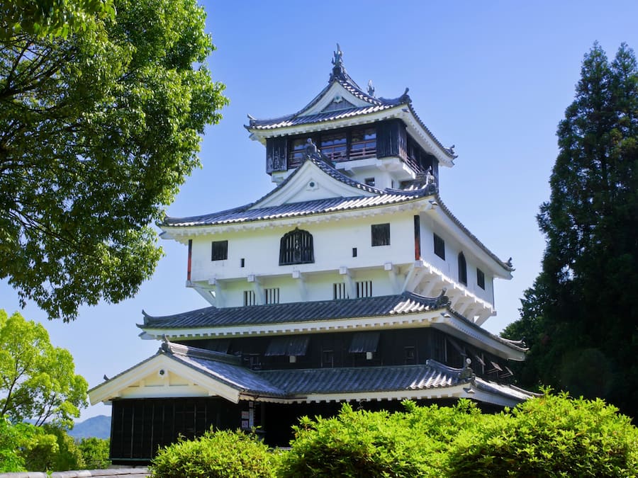 Un castillo japonés tradicional con varios niveles, paredes blancas y techos oscuros.
