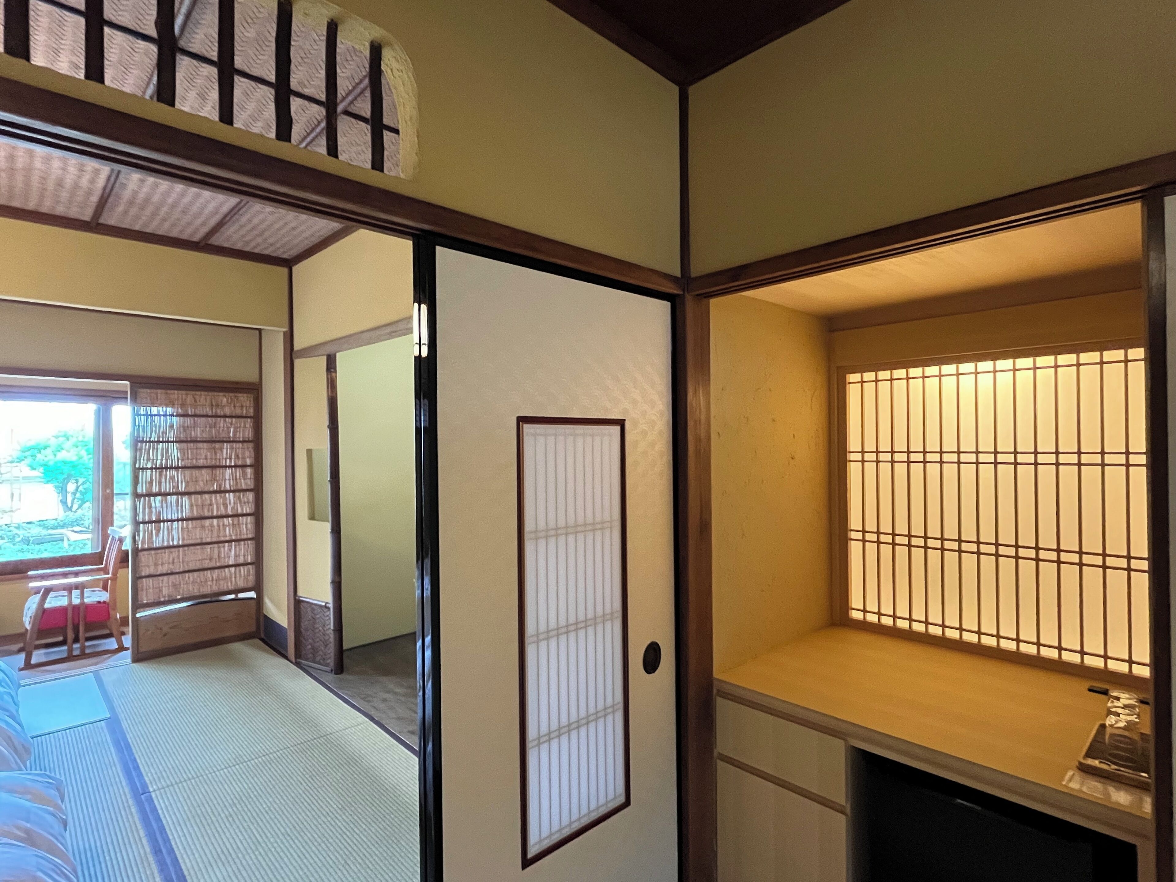 Una habitación japonesa tradicional con suelo de tatami, puertas correderas y un separador shoji.