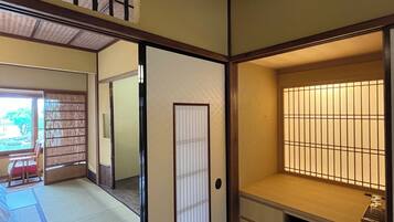 Una habitación japonesa tradicional con suelo de tatami, puertas correderas y un separador shoji.
