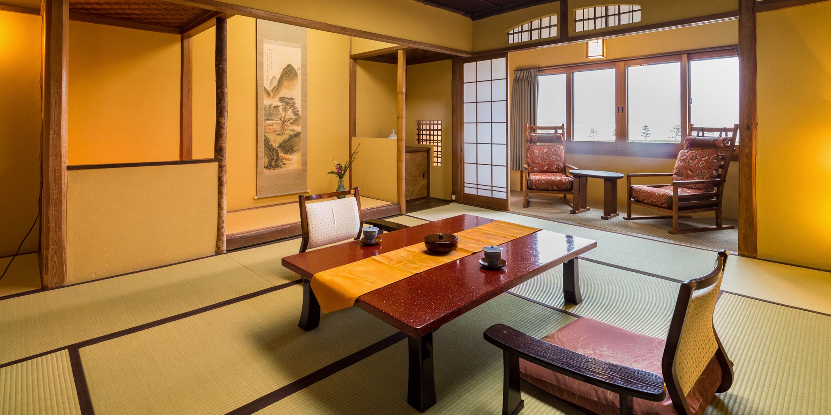 Una habitación japonesa tradicional con suelo de tatami, una mesa baja y muebles de madera.
