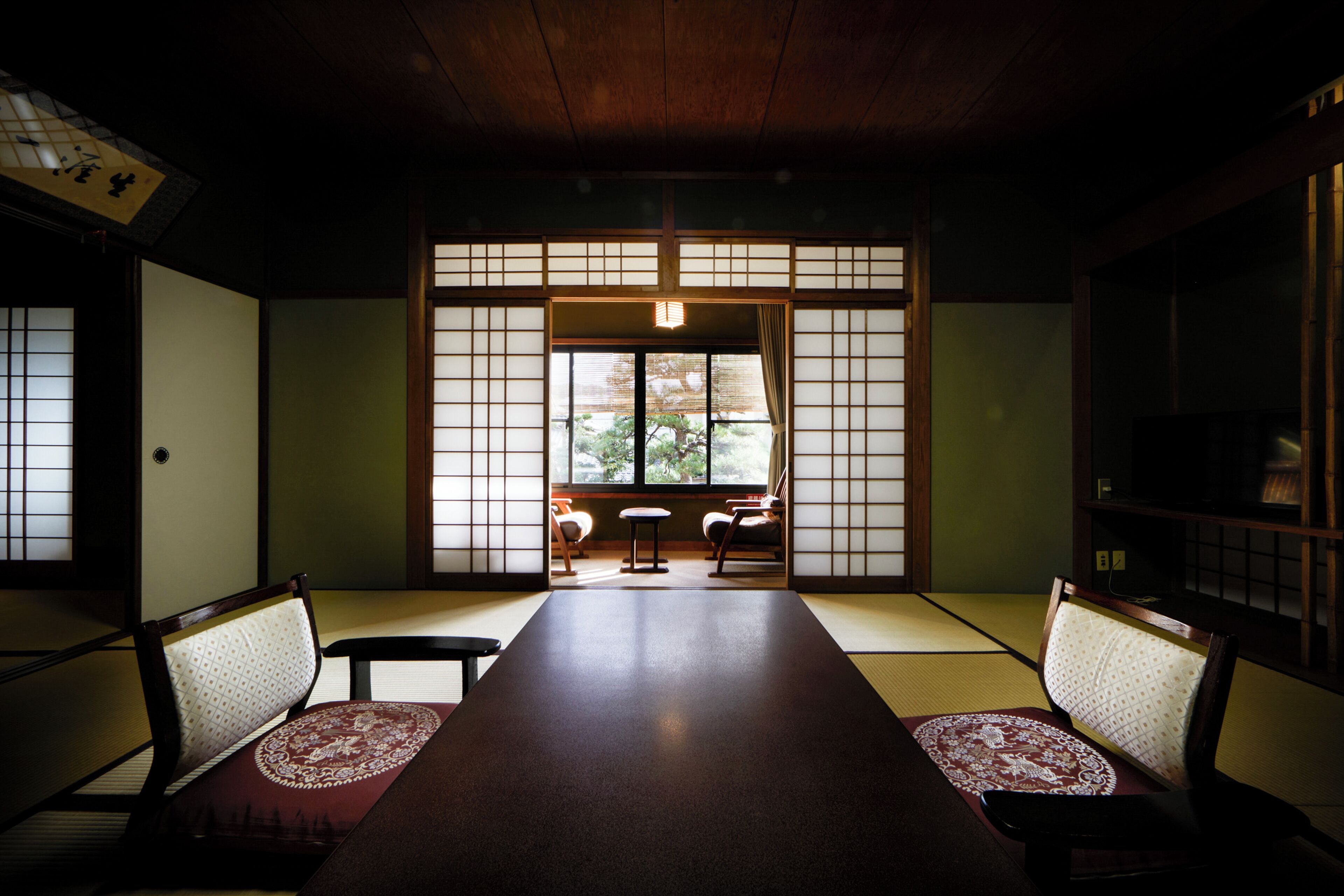 A traditional Japanese room with tatami flooring, a low table, and shoji screens.