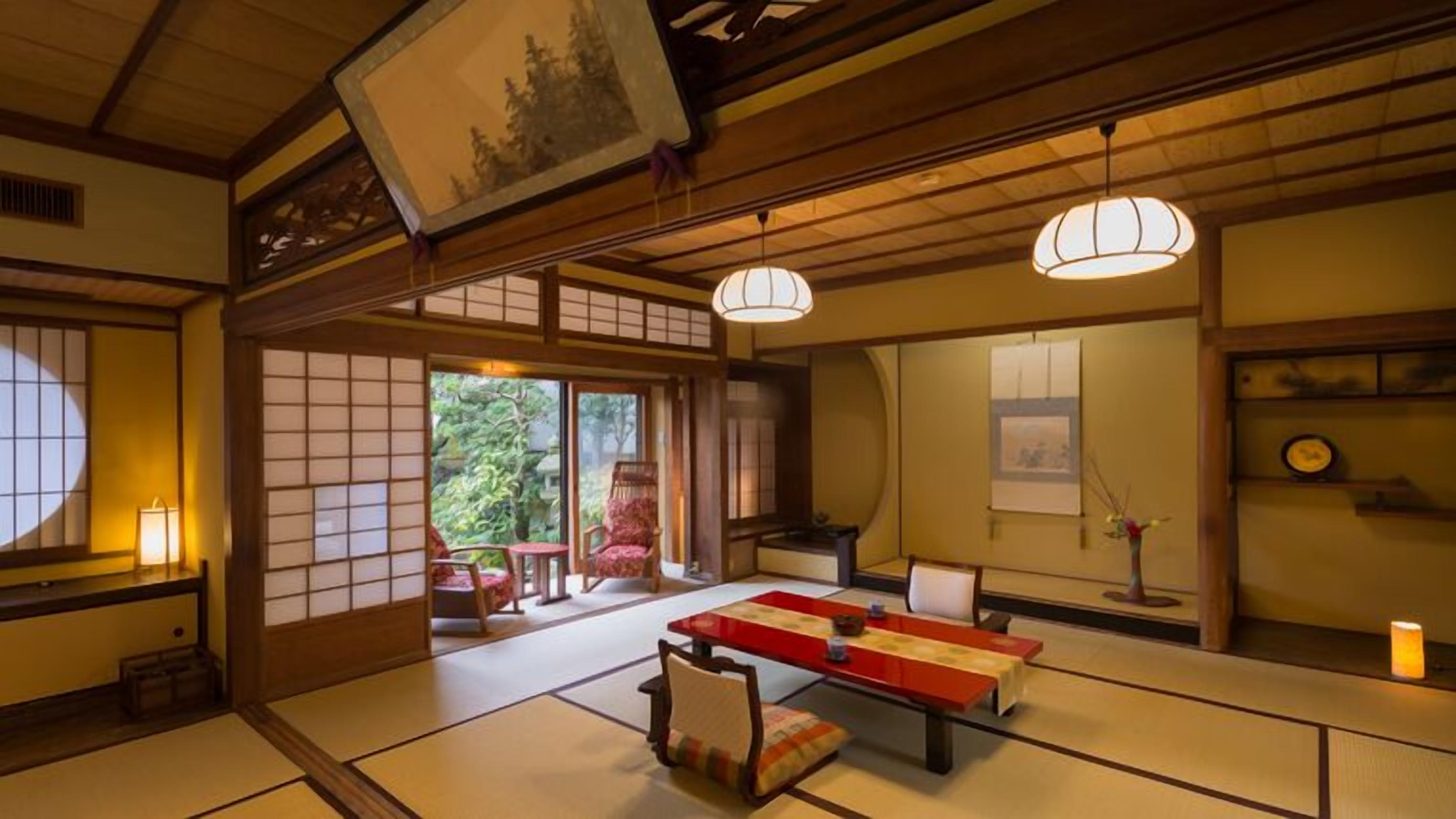 Une pièce de style japonais traditionnel, avec un sol recouvert de tatamis, une table basse et des portes coulissantes.