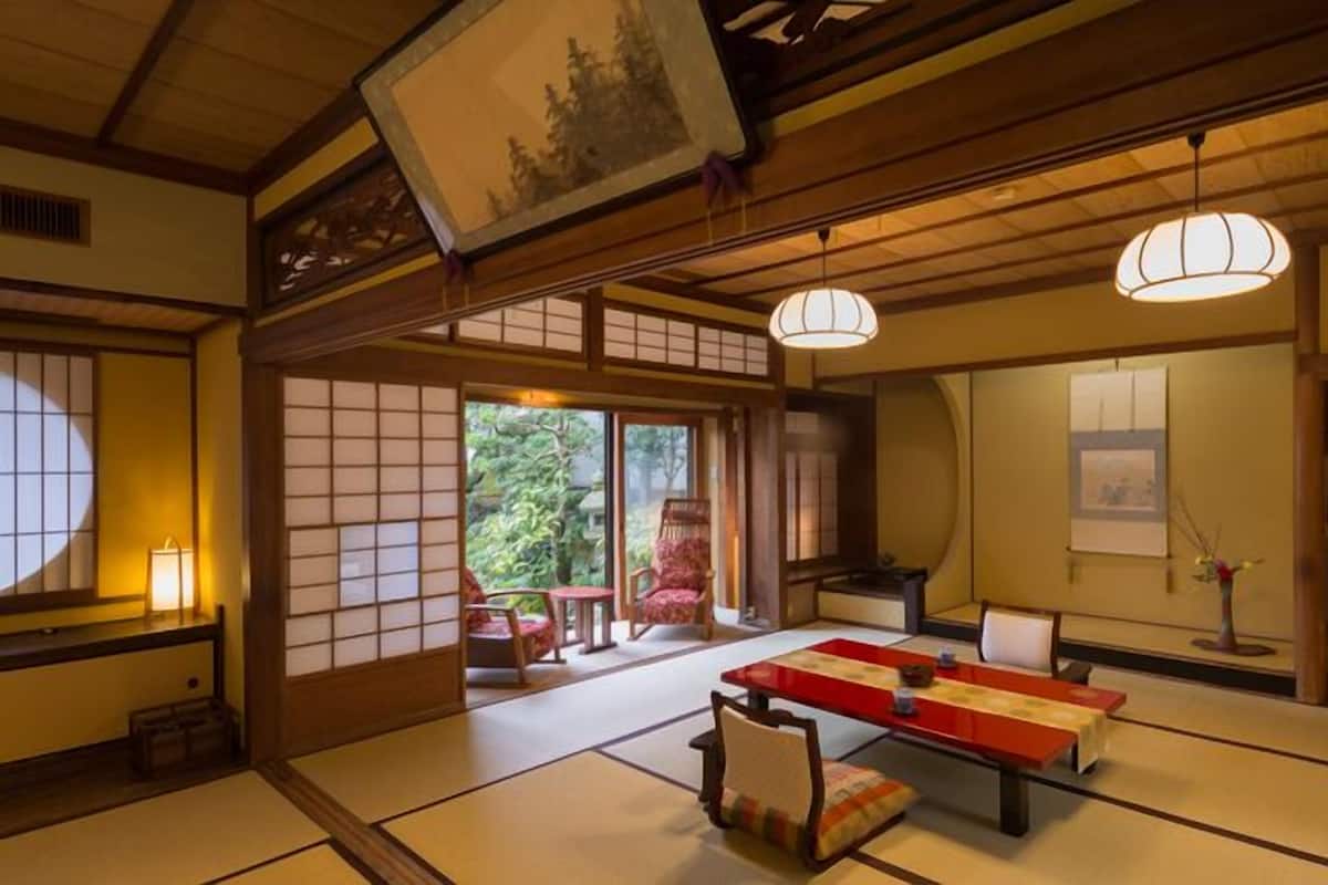 Um quarto japonês tradicional, com tatames, uma mesa baixa e portas deslizantes.