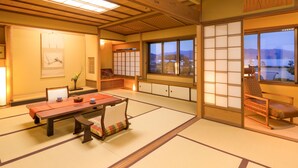 Una habitación japonesa tradicional con suelo de tatami, una mesa baja y una puerta corredera.