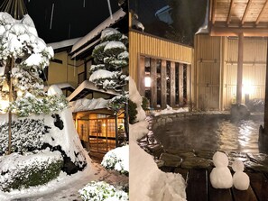 A traditional Japanese building with a wooden exterior and a stone pathway leading to a hot spring area.