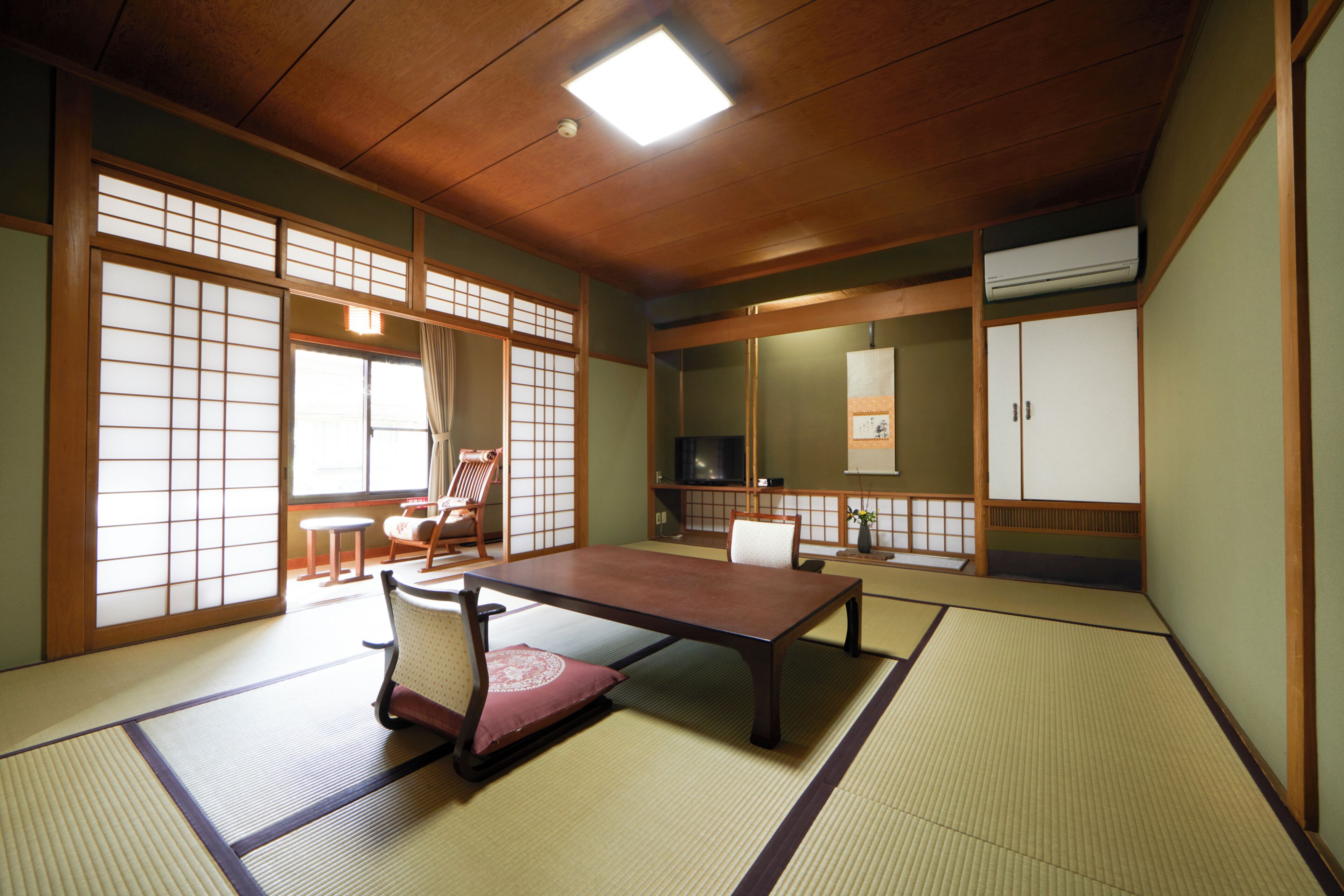 Une pièce de style japonais traditionnel, avec un sol recouvert de tatamis, une table basse et des portes coulissantes.