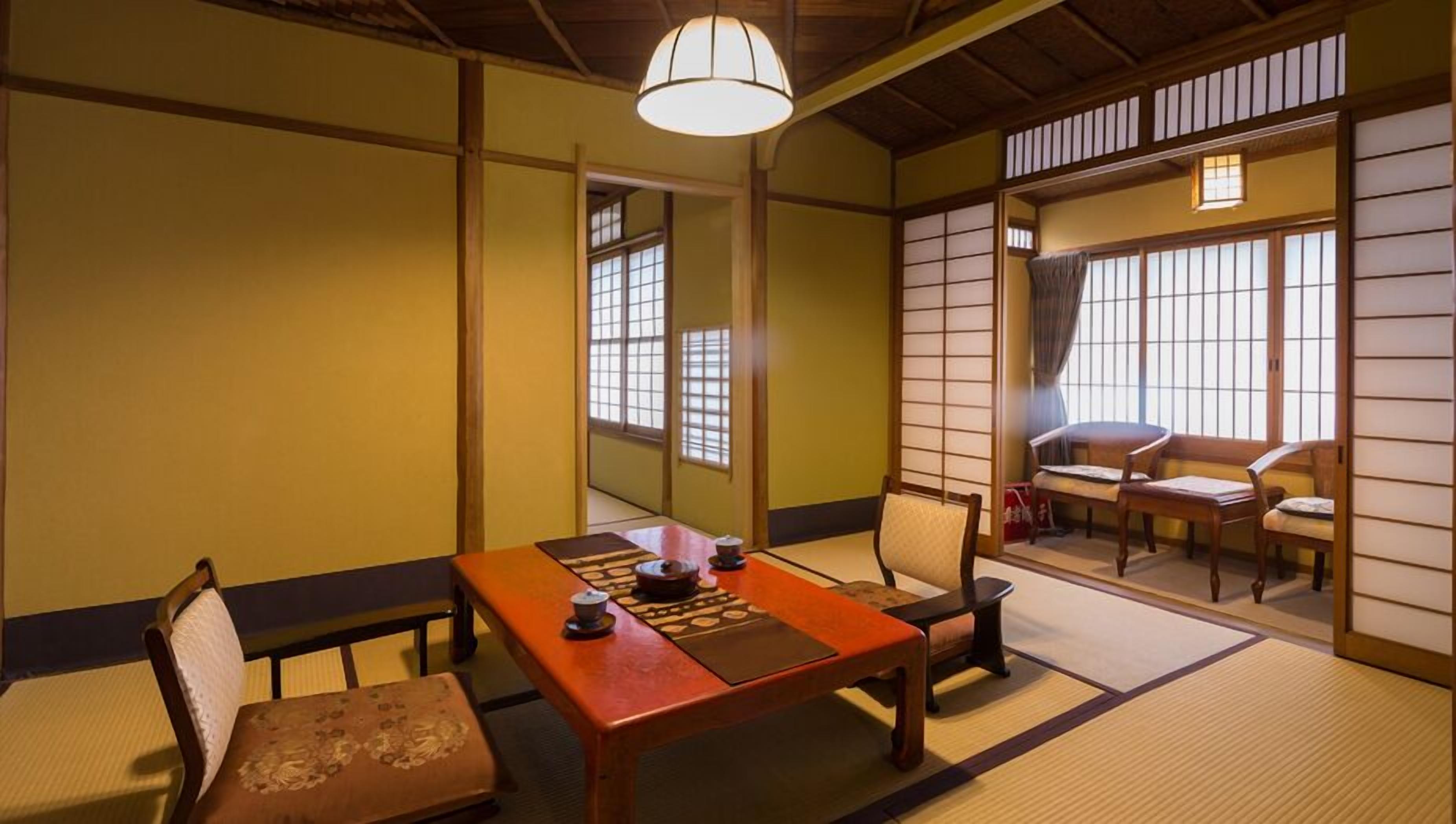 Une pièce de style japonais traditionnel, avec un sol recouvert de tatamis, une table basse et des portes coulissantes.