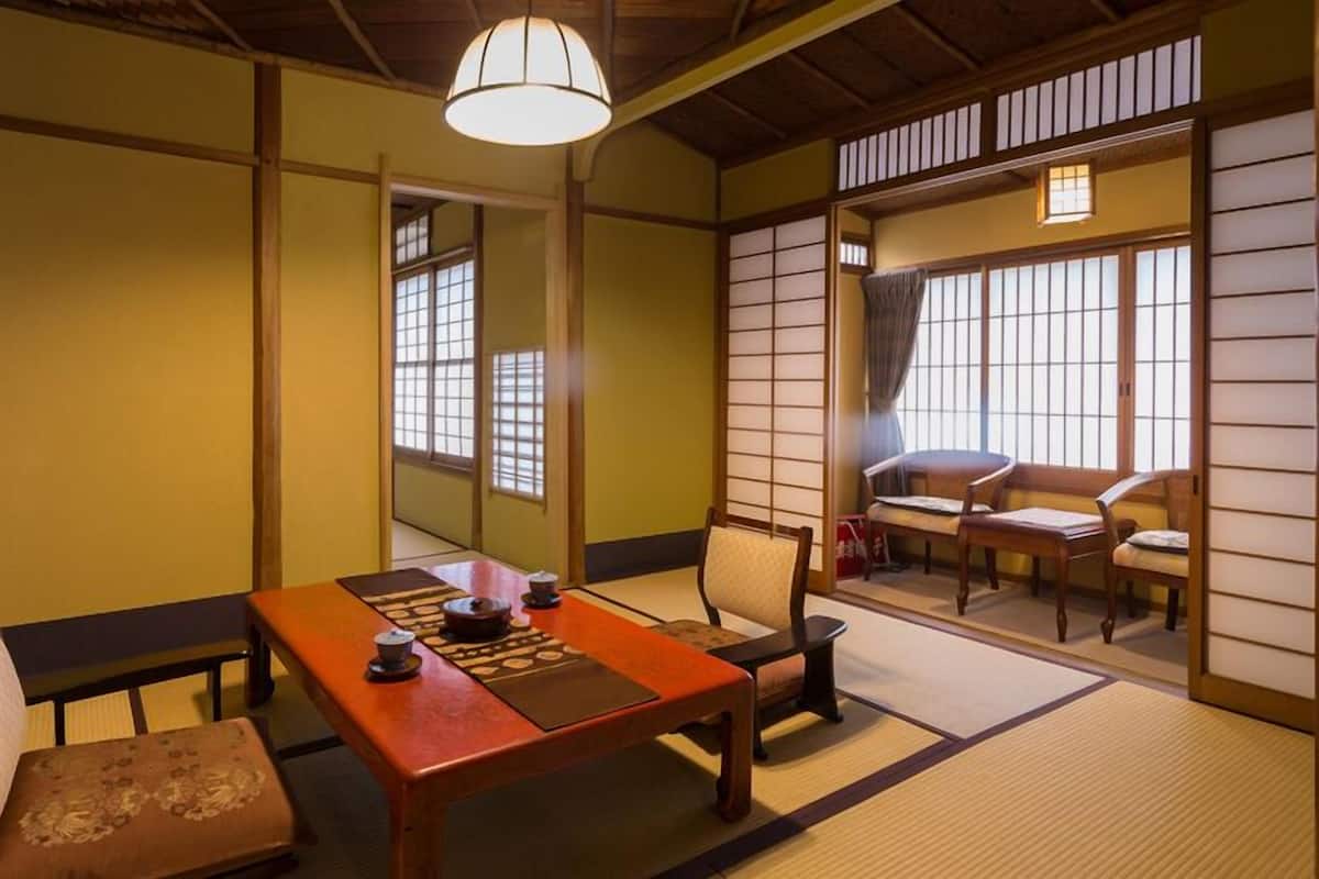 Um quarto japonês tradicional com tatames, uma mesa baixa e portas deslizantes.