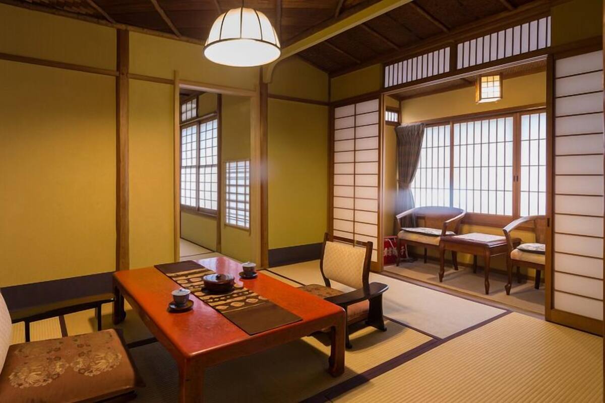 Une pièce de style japonais traditionnel, avec un sol recouvert de tatamis, une table basse et des portes coulissantes.