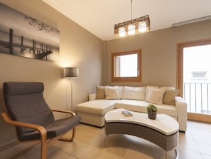 Relax in this stylish living room with a curved sofa, armchair, and floor lamp.