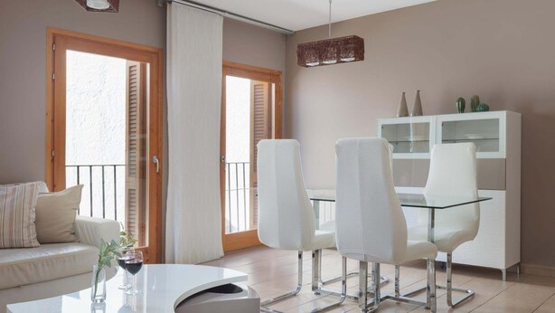 A modern living room with a sofa, a glass-top dining table, and white chairs. - MEDITERRANEAN APARTMENT 3 minutes TO THE BEACH 2 (Tossa de Mar)