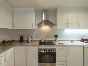 Enjoy cooking in this well-equipped kitchen with a gas stove, oven, and range hood.