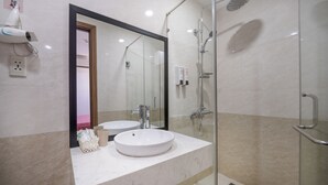 A modern bathroom with a large mirror, two sinks, a glass shower enclosure, and a marble countertop. - S HOTEL BEACH DA NANG (Da Nang)