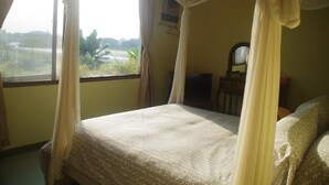 Een kamer met een bed, een televisie en uitzicht op het buitenland.