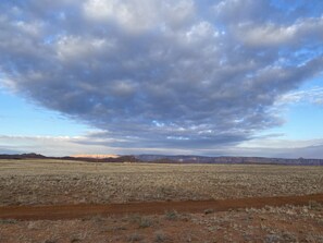 A vast, open landscape with a clear sky and distant mountains. - Traditional Navajo Hogan. Cultural experience! Near all attractions. (Page)