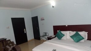 Ein Hotelzimmer mit einem Bett, zwei Türen, einem kleinen Tisch und einem Stuhl.