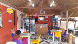 Ein Restaurant mit einer Theke, Sitzbereich und verschiedenen Speisen und Getränken.