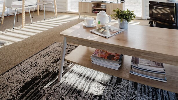 Una sala de estar acogedora con techo de madera, televisor, chimenea y comedor con mesa y sillas.