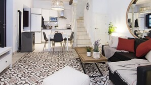 Una sala de estar moderna con comedor, cocina y escalera.