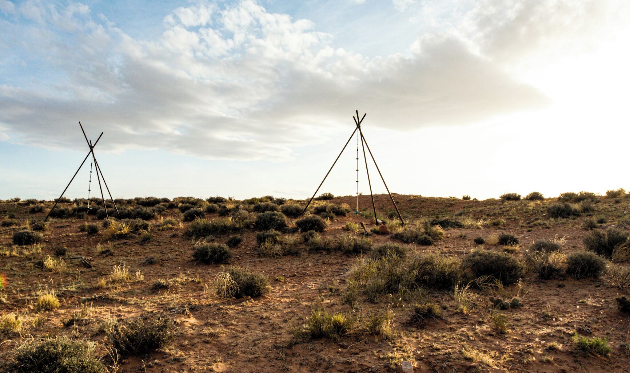 A desert landscape with two simple, triangular structures.