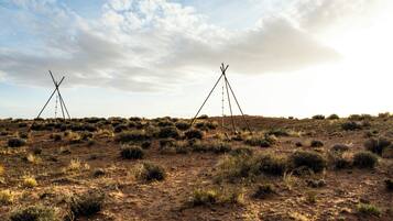 A desert landscape with two simple, triangular structures.
