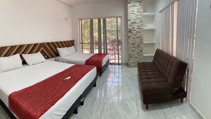 Une chambre d’hôtel avec deux lits, un canapé, un mur décoratif en pierre et un balcon avec vue.