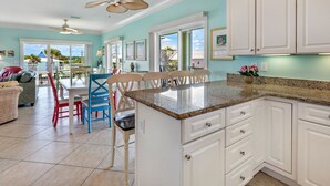 A spacious kitchen with white cabinets, a granite countertop, and a ceiling fan. - Sea Urchins, Unit 2. 5 BR. Beachview. The Beach, so close, for less! Pool. (Gulf Shores)