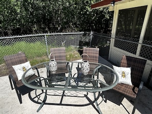 Relax in style with a round table and wicker chairs on this serene patio, surrounded by lush views.
