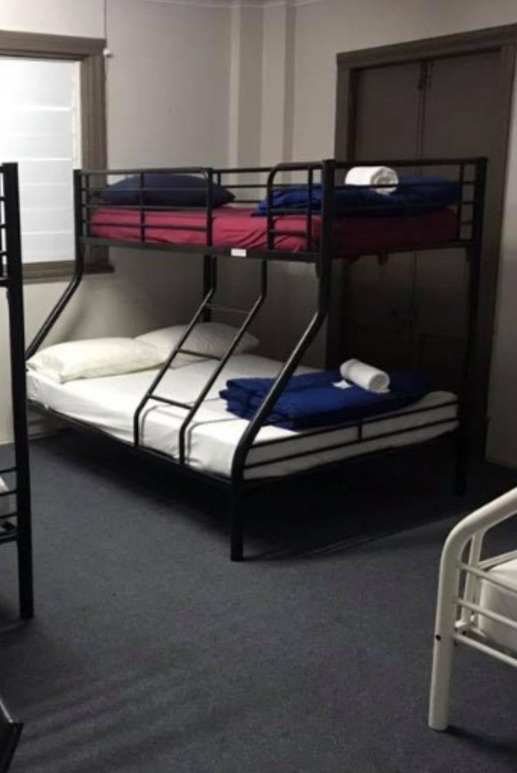 A bunk bed with a mattress, pillows, and a blanket.
