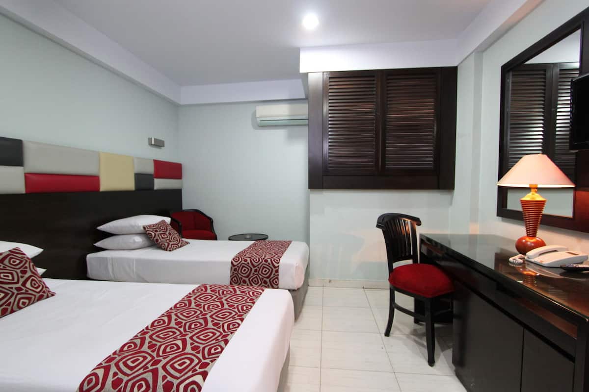 Une chambre d’hôtel avec deux lits, un bureau, une chaise, une lampe et un téléviseur.