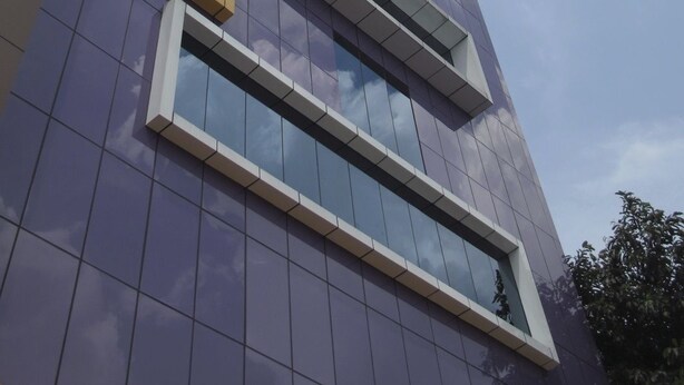 A modern building with a glass facade and a geometric design. - Hotel Alma (Jakarta)