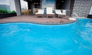 Relax by the pool with two lounge chairs and a clear view of the water.
