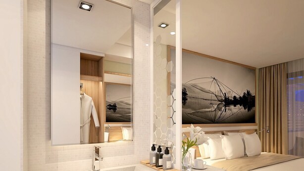 A modern hotel room with a large mirror, a wooden vanity, a bed with a view of the city, and a painting on the wall.