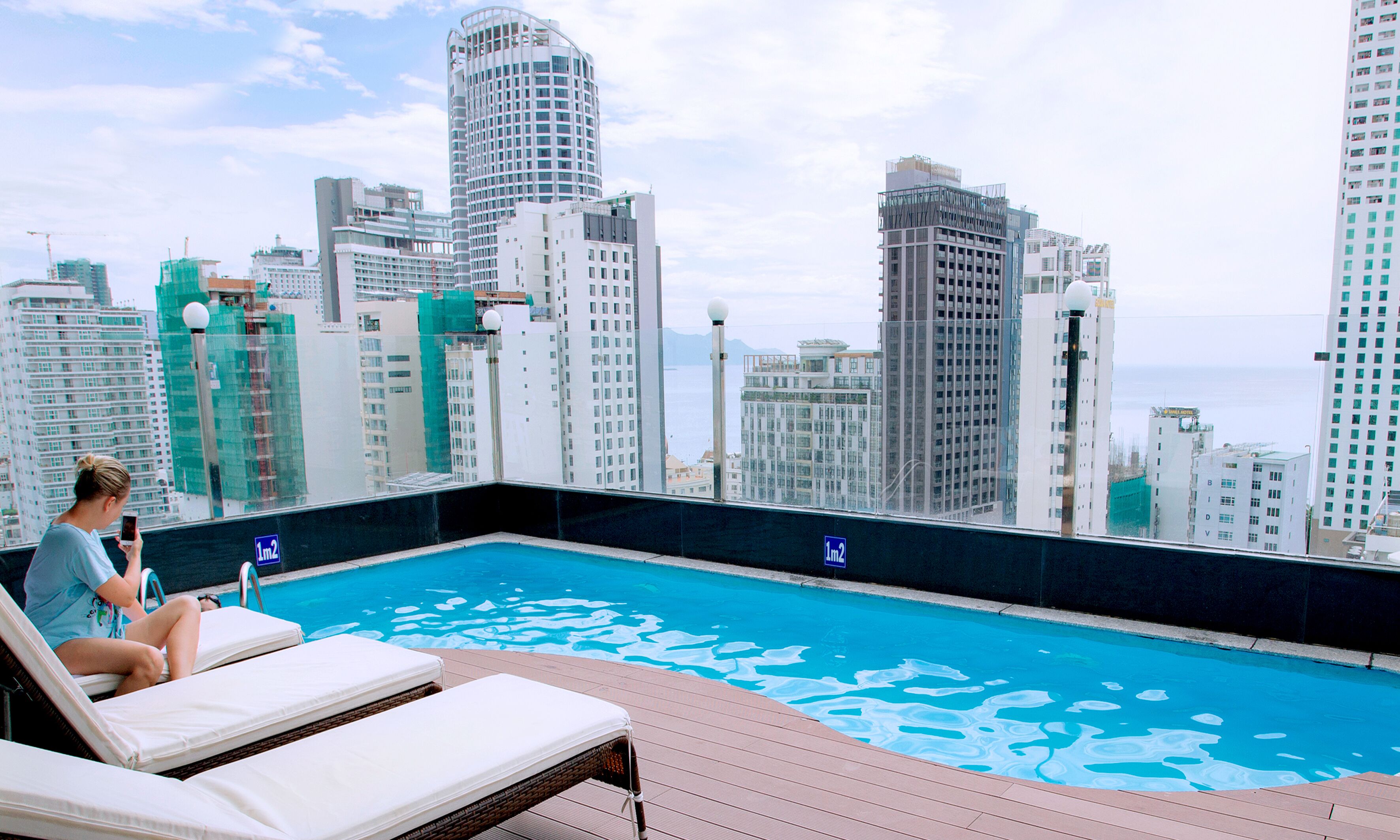Una piscina al aire libre, sillones reclinables de piscina