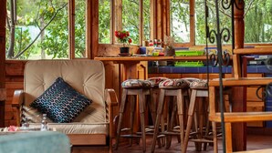 Un interno in legno rustico con un'area bar, una poltrona imbottita e un pavimento decorato.