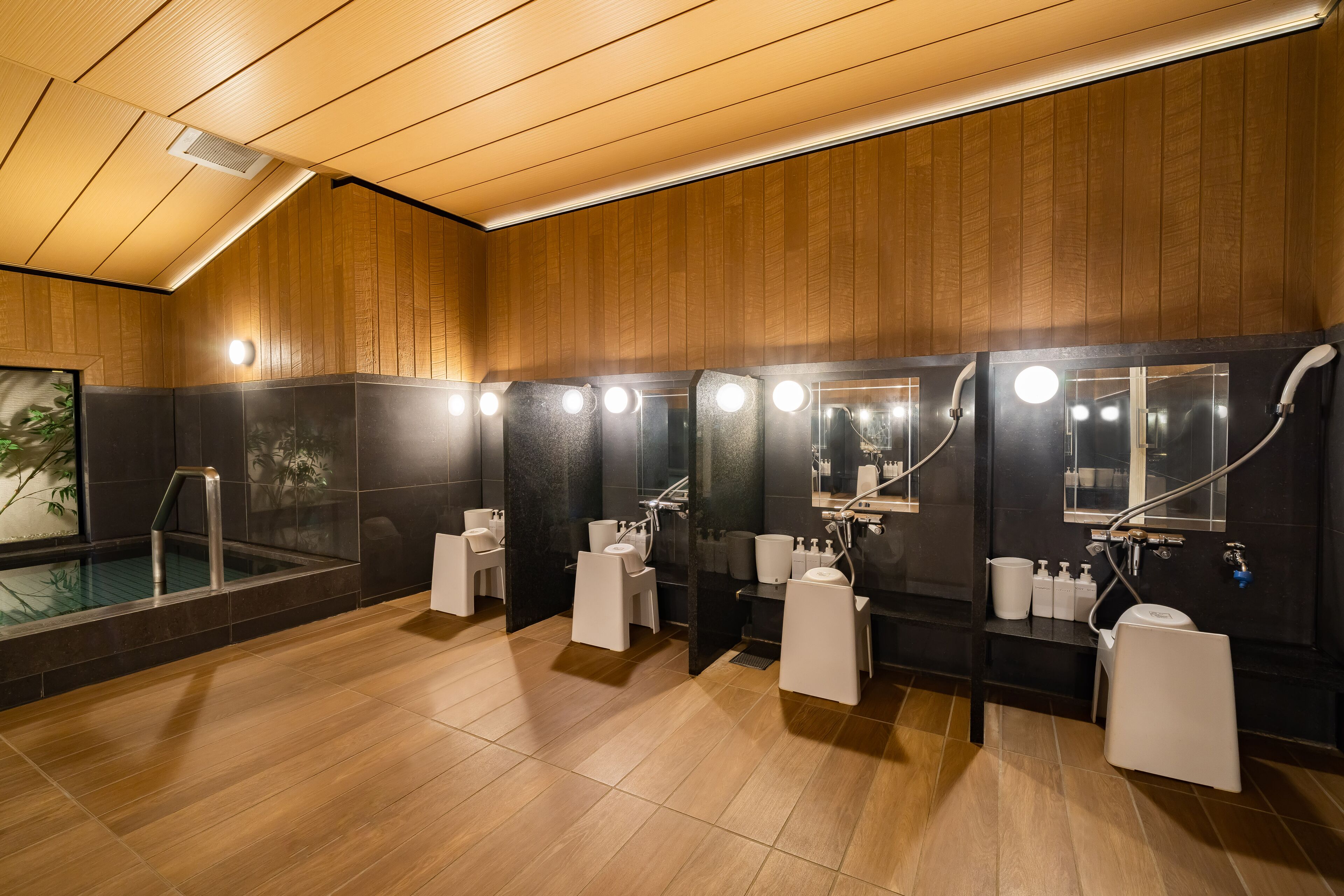 A modern bathroom with wooden paneling, a glass-enclosed hot tub, and multiple sinks with mirrors.