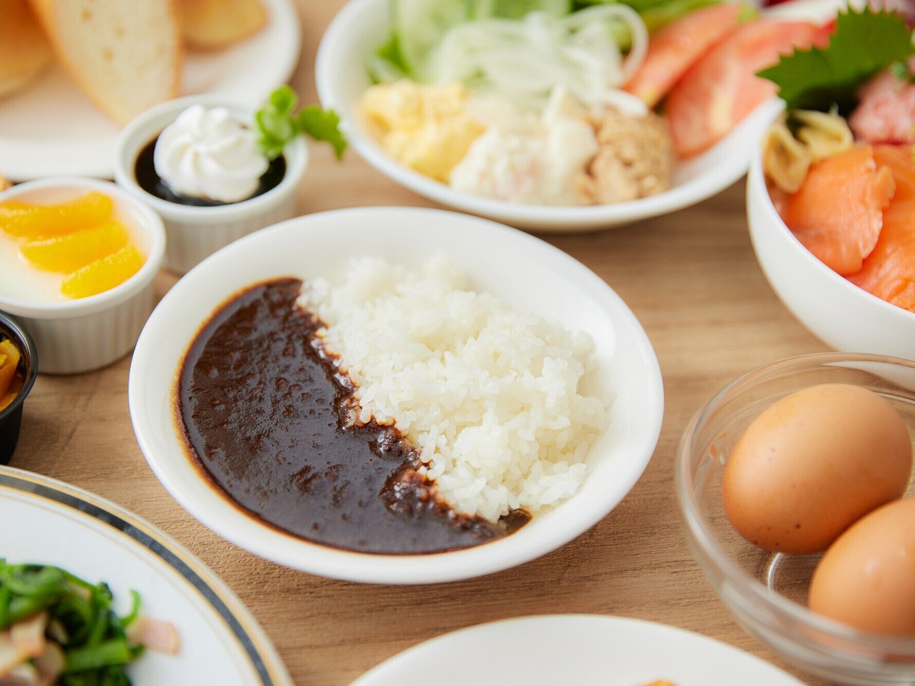 Una mesa con diferentes platos que incluyen arroz, una salsa oscura y otros alimentos.
