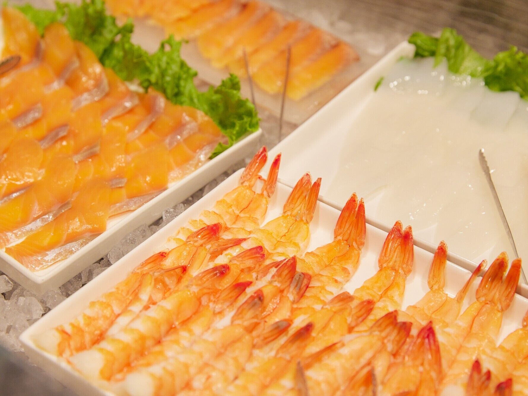 Een schaal vol zeevruchten met garnalen en zalm, gepresenteerd op een ijsbed.