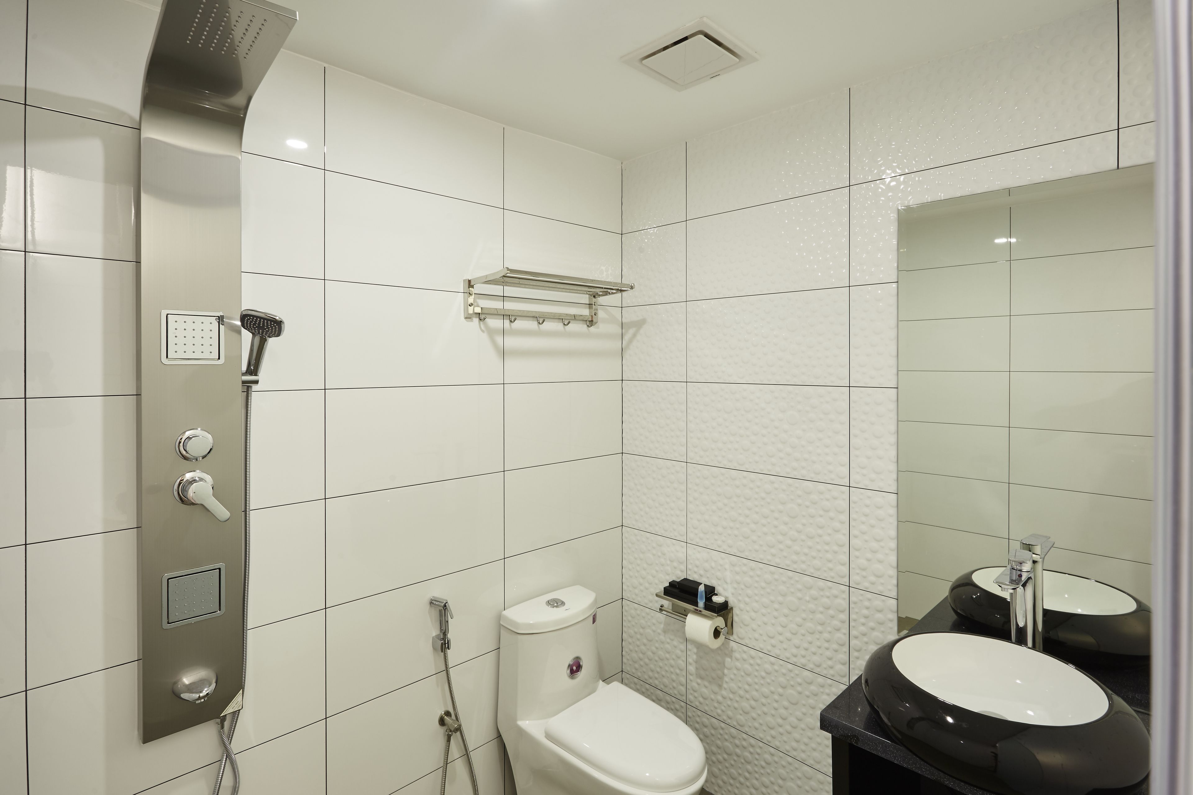 A modern bathroom with a shower, toilet, and sink.