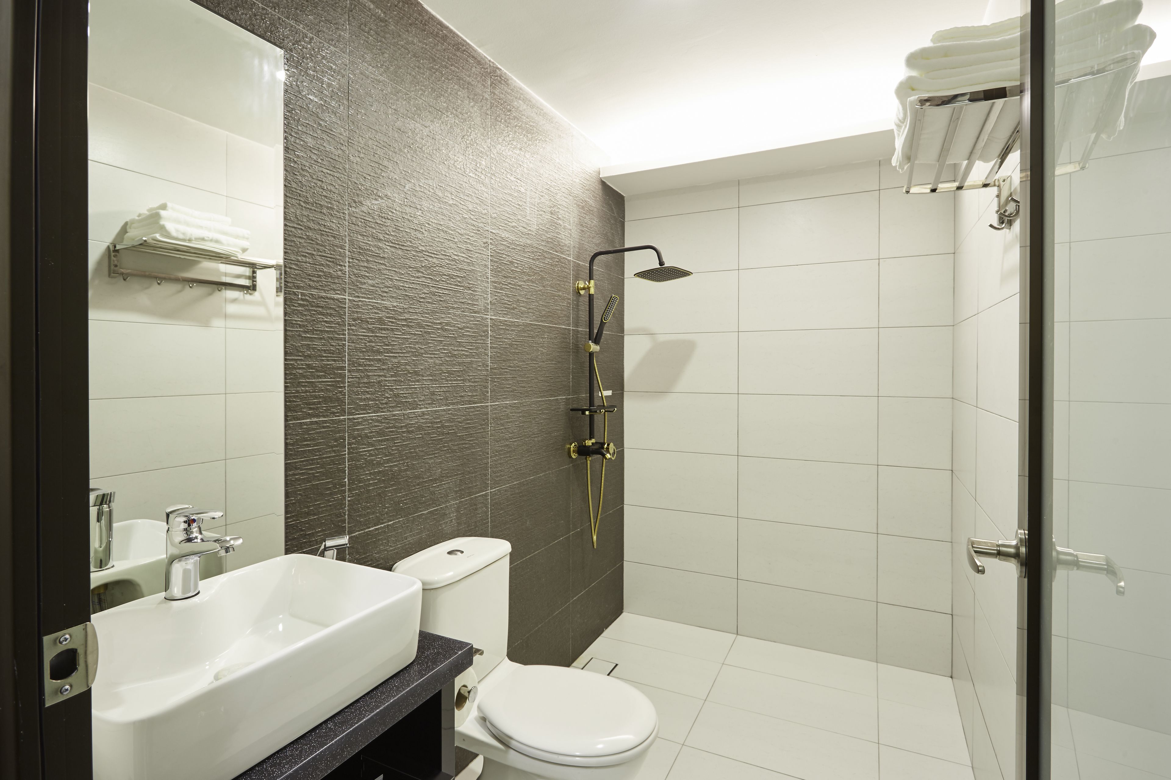 A modern bathroom with a white sink, toilet, and shower.