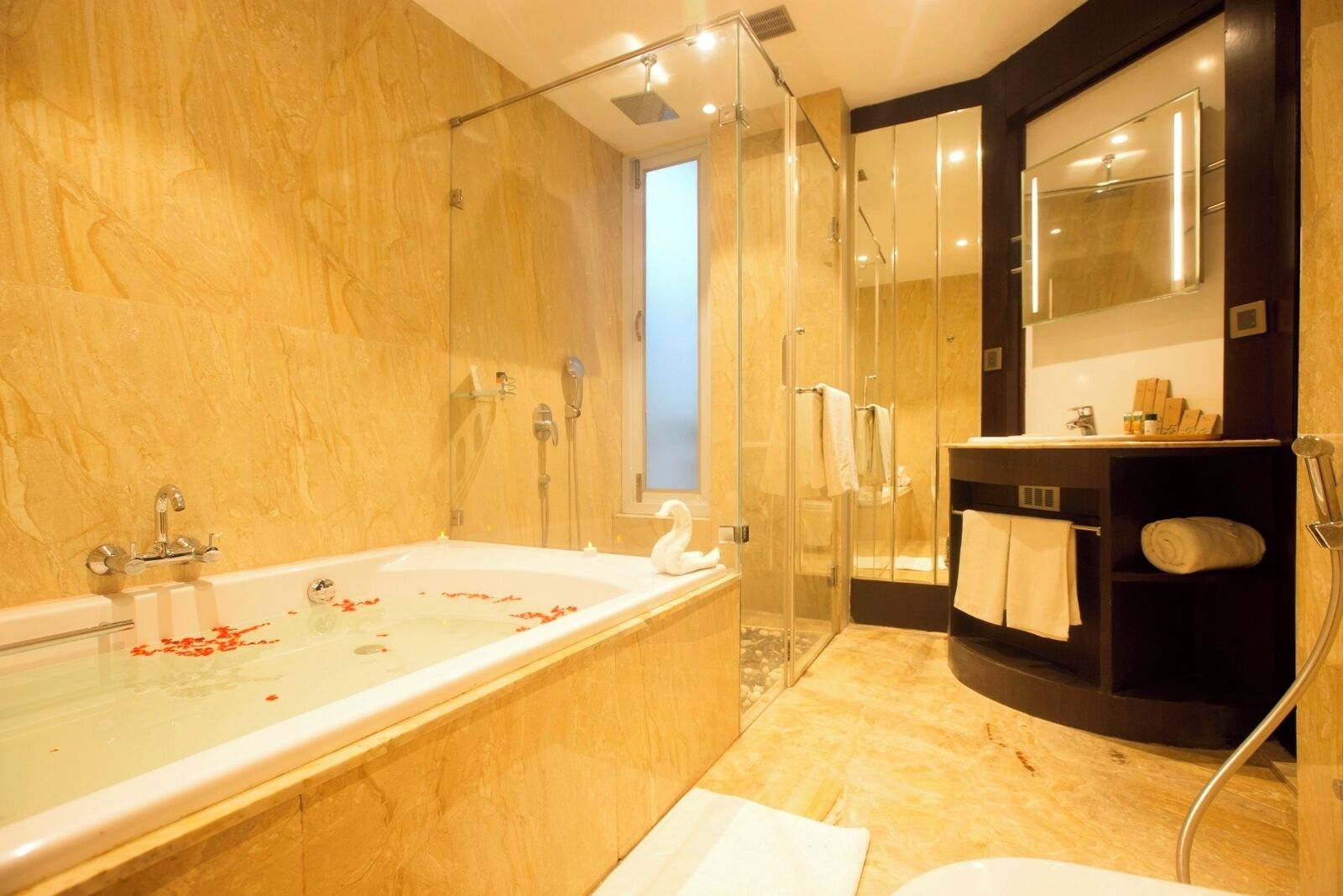 Un baño moderno con una bañera grande, cabina de ducha de vidrio y tocador con espejo.