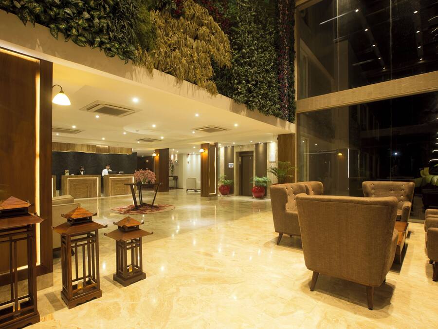 A lobby with a reception desk, seating area, and a large window.