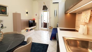 A compact hotel room with a dining area, kitchenette, and a view through a door. - Lovely apartments Marmont with balconies in the heart of Split (Split)