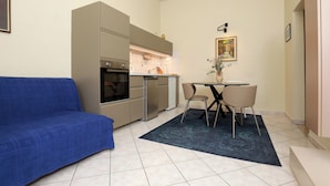 A compact kitchen with a built-in oven, a dishwasher, and a small dining area with a table and chairs. - Lovely apartments Marmont with balconies in the heart of Split (Split)