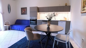 A compact living space with a dining area, kitchenette, and a sofa. - Lovely apartments Marmont with balconies in the heart of Split (Split)